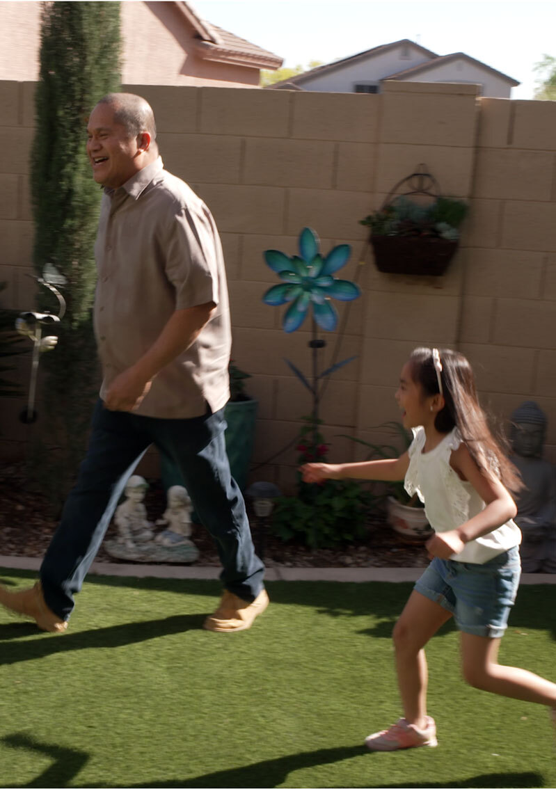 Man and child playing in a backyard